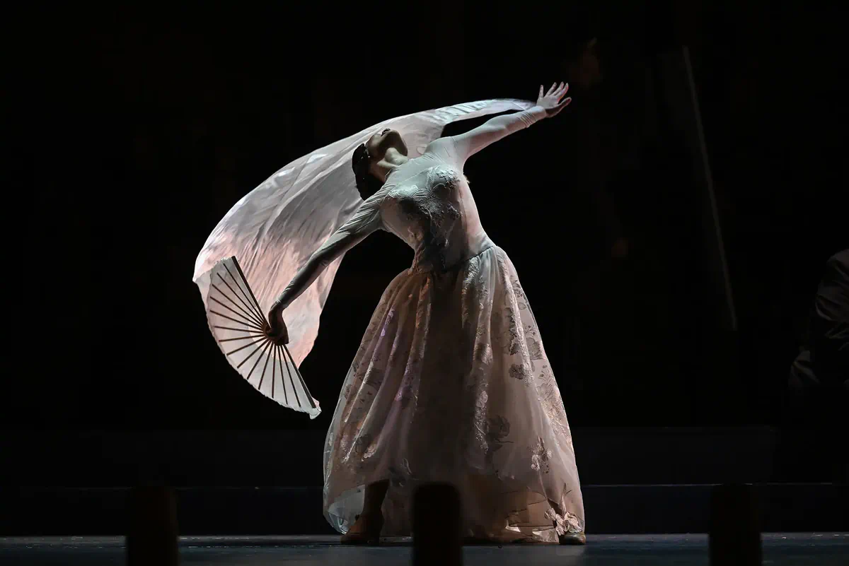 Escena de Goyescas con una bailarina sosteniendo un abanico y un velo blanco extendido.